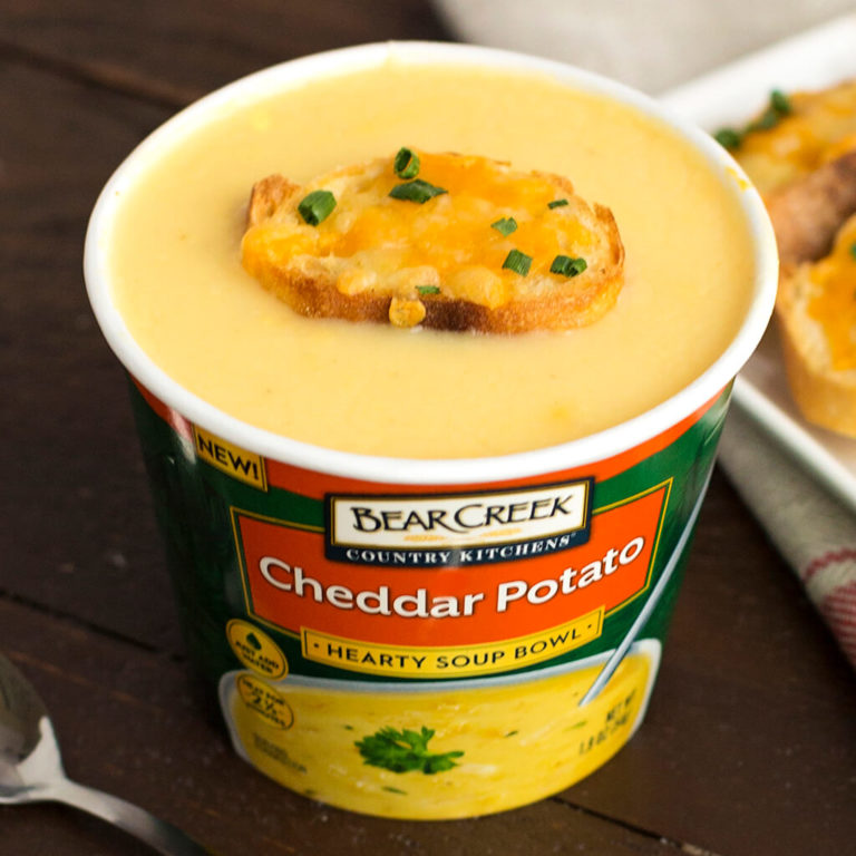 Bear Creek Cheddar Potato Soup Bowl with toast, ideal for quick meals, on a wooden surface.